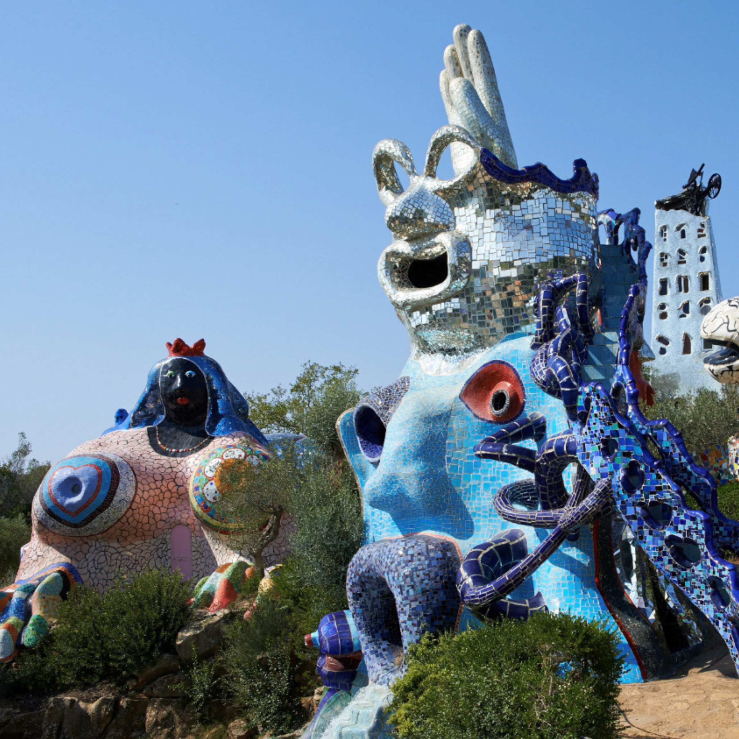 Ein Skulpturengarten mit bunten Figuren aus Mosaik.